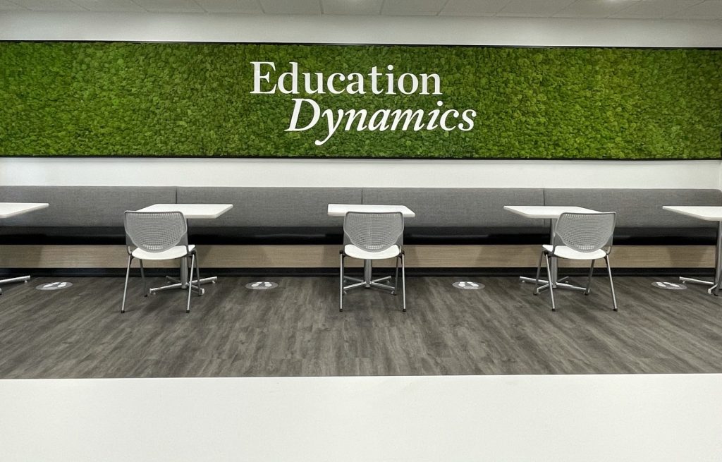 A bright green moss wall spans the width of the room at Education Dynamics. 